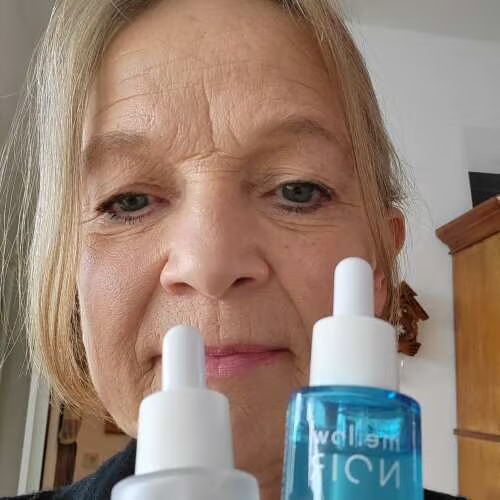 Nahaufnahme einer Kundin mit zwei Serum-Flaschen von mellow NOIR