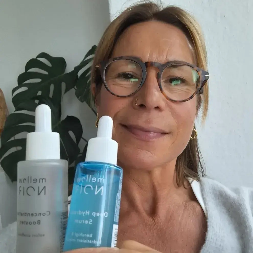 Kundin mit zwei Serum-Flaschen von mellow NOIR